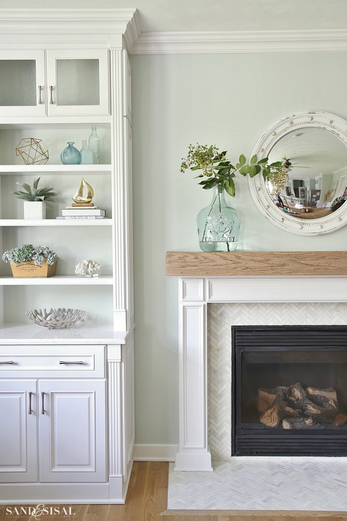 Coastal Family Room and Fireplace Makeover. One year after a flood, come see what we did to reinvent this space! Built-in bookcases and a DIY wood beam mantel with marble herringbone tile surround, give this room a relaxed yet classic coastal chic feel.